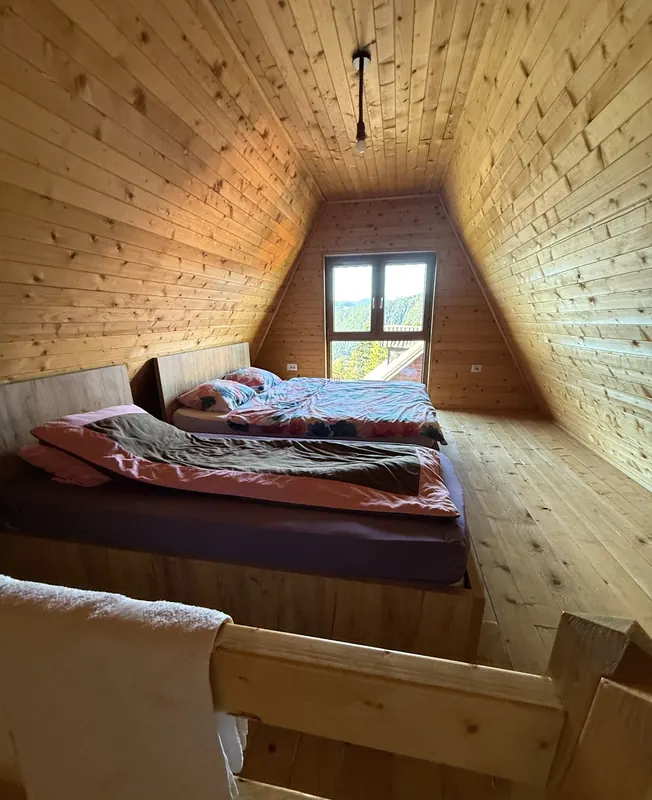 Loft bedroom with two beds and a gable window