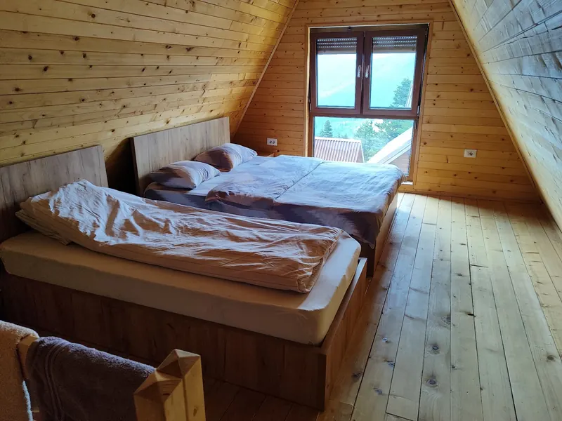 Bright loft bedroom with two beds on a pine floor
