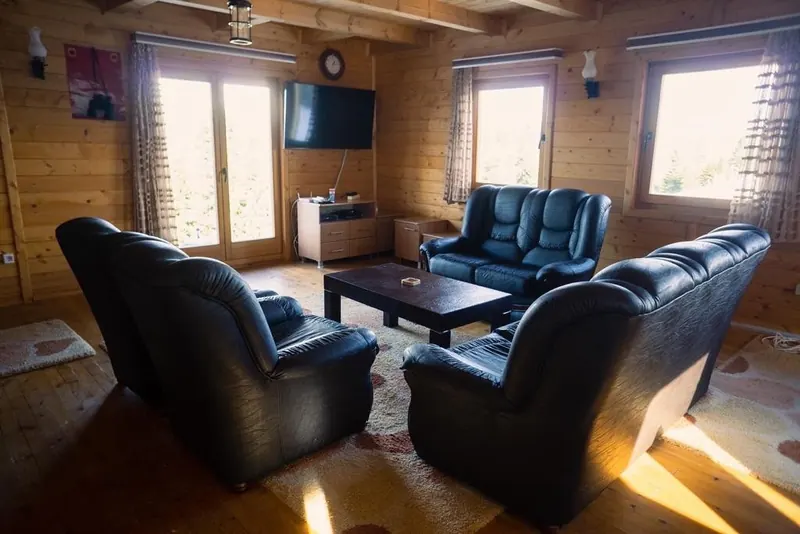 Wood-panelled lounge with leather sofas and sunlight from tall windows